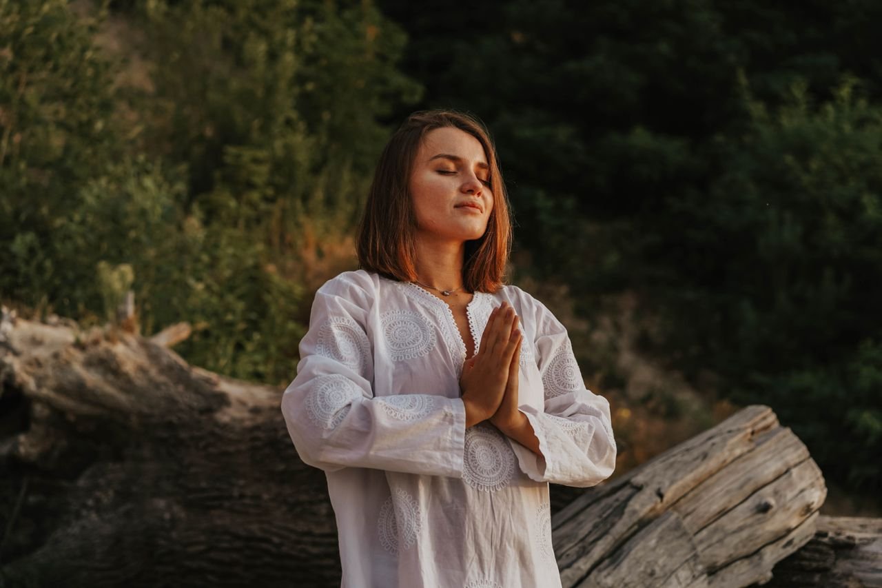 Mastering the First Impression: Your intriguing post title goes here A woman with short hair meditates outdoors, embracing tranquility amidst nature.